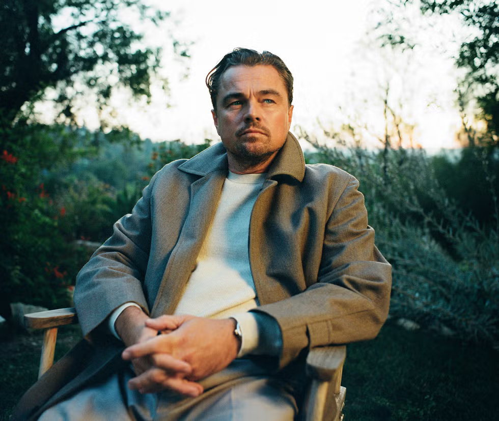 man seated outdoors in a casual setting wearing a stylish coat